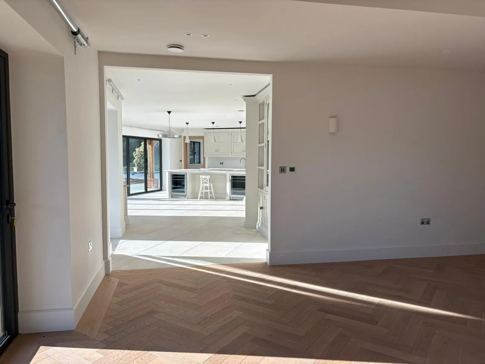 Herringbone oak flooring leading through to an open-plan kitchen | Northfold Flooring