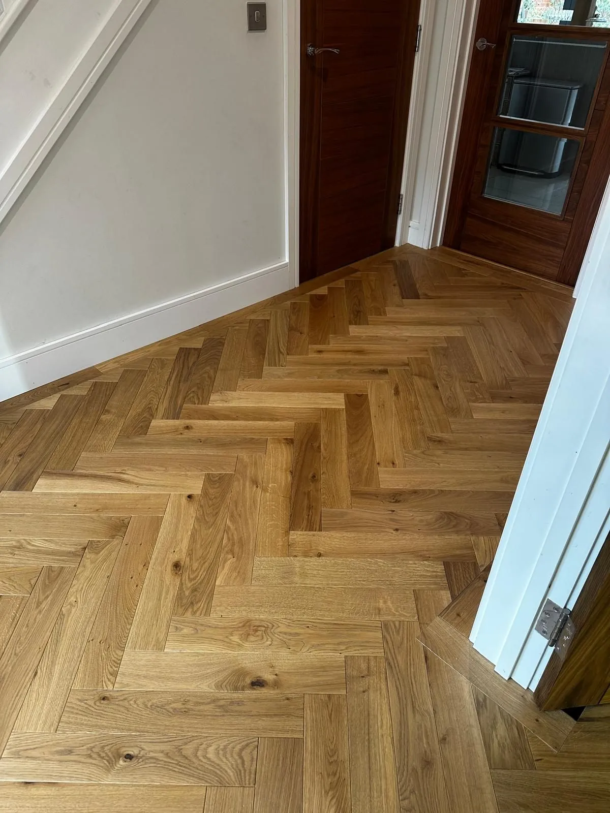 Herringbone oak flooring installed in a hallway beside the stairs | Northfold Flooring