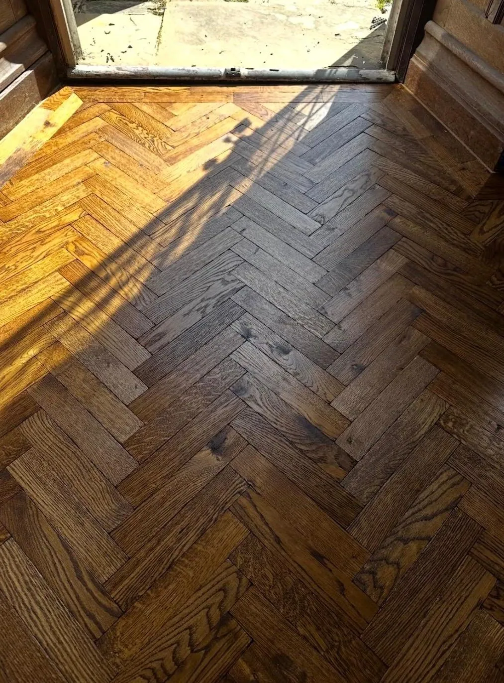 Restored period oak parquet in sunlight at a doorway | Northfold Flooring