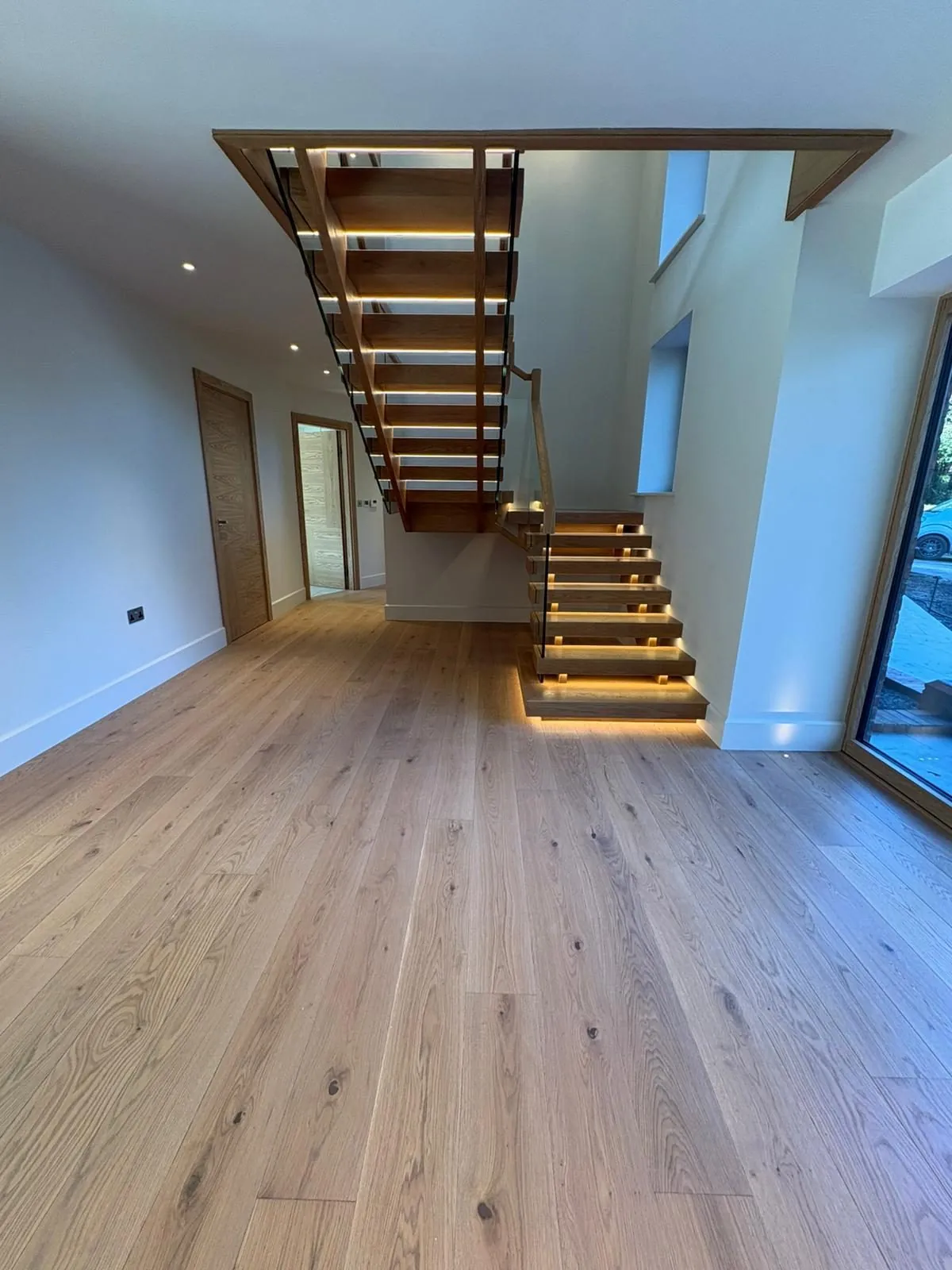 Wide engineered oak planks running towards a floating oak staircase | Northfold Flooring