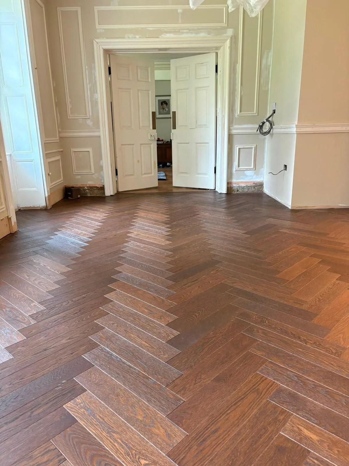 Dark herringbone oak flooring installed in a period room with panelled double doors | Northfold Flooring