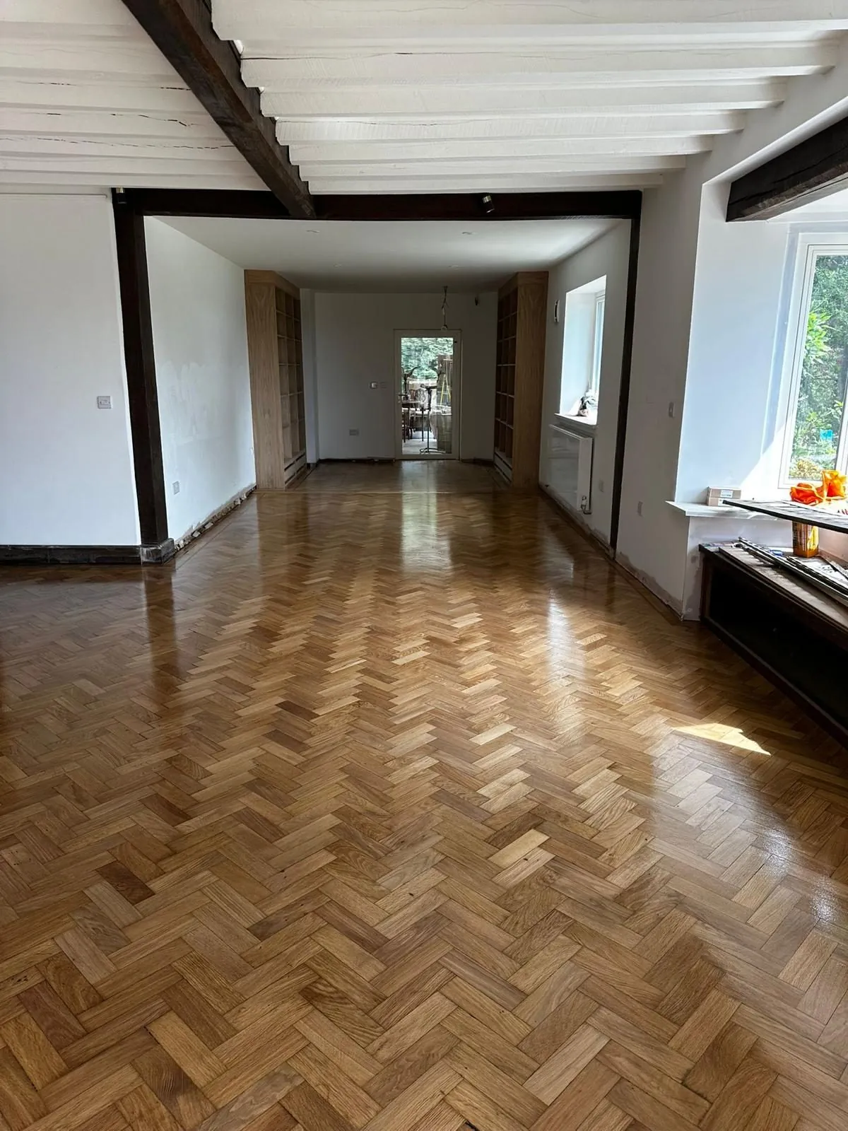 Oak herringbone parquet sanded and refinished to a gloss in a long beamed room | Northfold Flooring