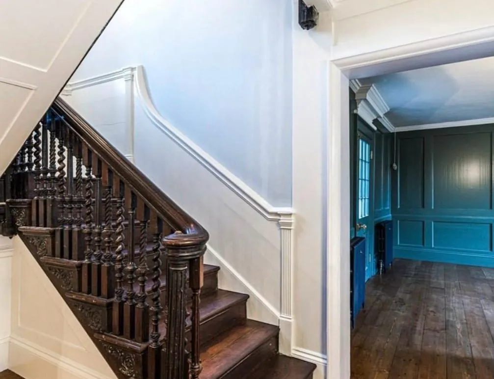 Restored pine floorboards in a period hallway beside a dark wooden staircase | Northfold Flooring